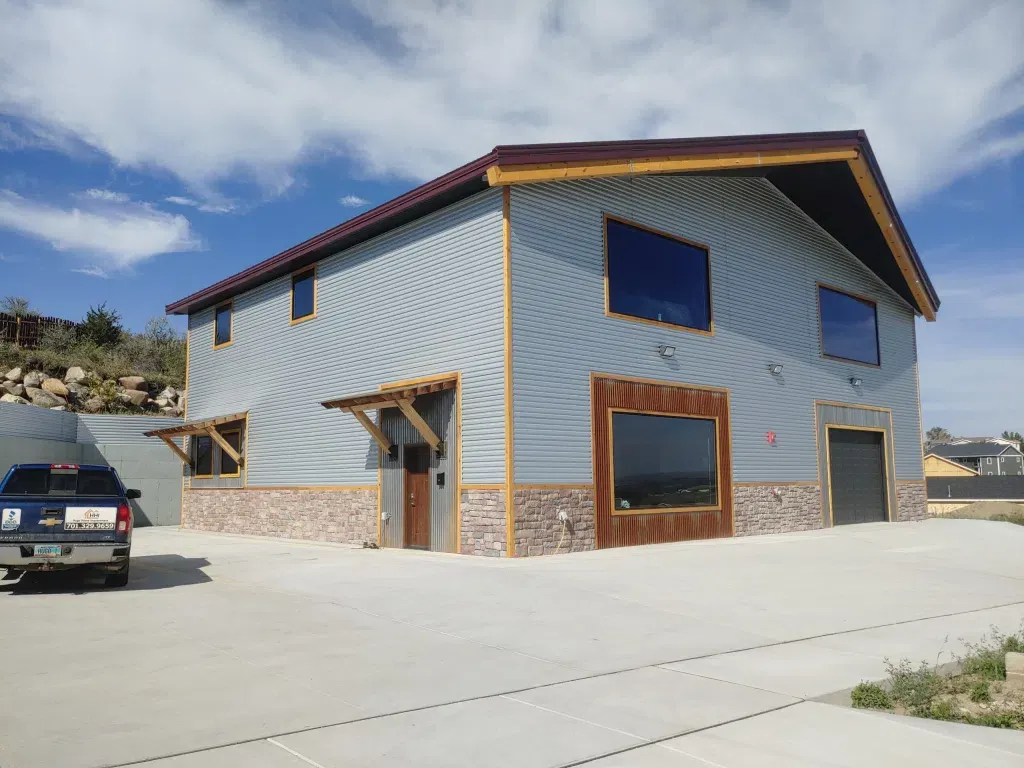 Two-story Advanced barndominium with stone wainscot and varied rooflines