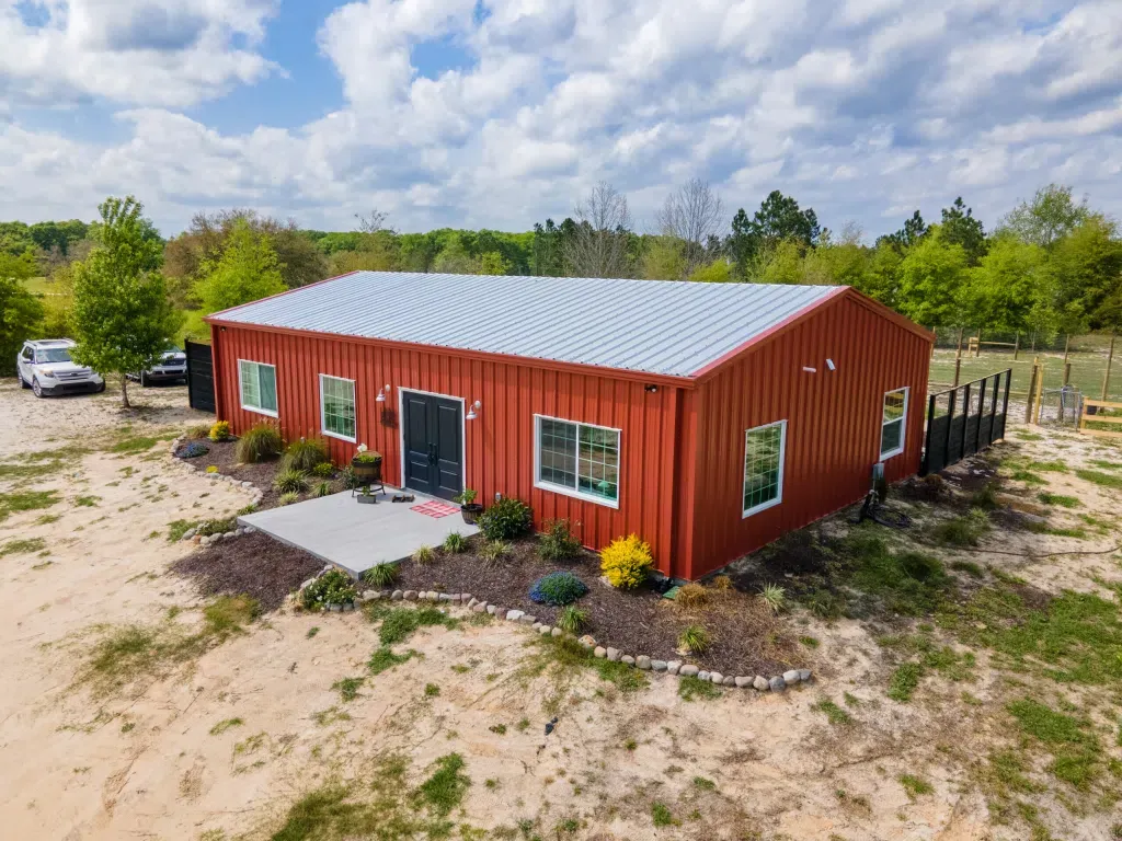 Red single-structure Basic barndominium with a standing porch