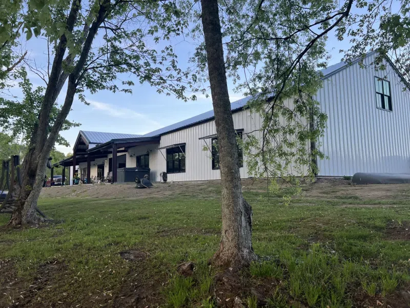 Lux barndominium in Tennessee with covered front porch and landscaping